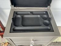 Top view of the inside of the table's top drawer showing molded foam organizer insert with various compartments.