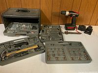 Wide view of entire tool set including power drill, battery chargers, hammers, wrenches, sockets and organizer drawers