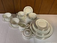 Full set showing plates, cups, saucers, sugar bowl and cream jug arranged on table