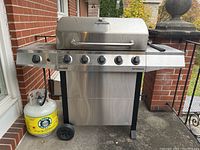 Front view of the Char-Broil Performance barbecue grill with propane tank attached showing 6 control knobs and stainless steel body.