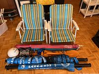 Full view of all items: two beach chairs, volleyball with net, beach umbrella in bag, two plastic shovels.