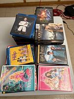 Photo showing DVDs and Blu-rays with titles like James Bond Spectre, Star Wars The Force Awakens, Columbo, Help!, Harry Potter, Barbie, and The Little Mermaid.
