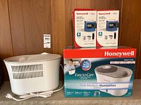 One opened Honeywell humidifier unit, two sealed boxes of Honeywell replacement wicking filters, and one sealed Honeywell Cool Moisture Humidifier box shown.