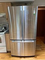 Front view of LG stainless steel French door refrigerator with closed doors and bottom freezer drawer.