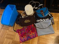 Overview of all bags including Italian leather bags, small crossbodies, Adidas backpack and colorful patterned purse with storage bin