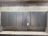Front view of six-door grey garage storage cabinets mounted on wall.