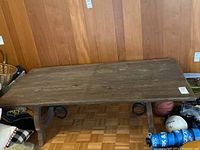 Angular view of the vintage wooden table showing rectangular top, wood grain, and leg supports.