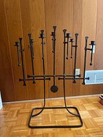 Front view of the large wrought iron candelabra showing the rectangular base and eight candle holders arranged horizontally.