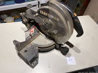 Front view of the Craftsman compound miter saw showing the blade, handle, and metal base with angle markings.