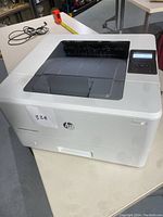 Full view of the HP LaserJet Pro M402n printer showing its design, dimensions, and top paper input tray