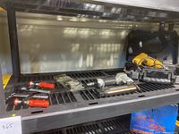 Overview of lot showing Husky brad nailer, DeWalt drill with case, two Bessey clamps, deburring kit and small tools on black grate shelf