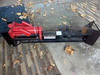 Side view of the black and red hydraulic log splitter showing the main hydraulic components and frame.