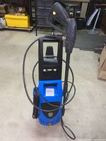 Full front view of the blue and black Pacific Hydrostar electric power washer with attached hose and spray gun.
