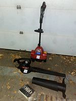 Photo showing Toro Power Shovel and Toro Super Blower Vac with bag and blower attachments on the ground in front of a garage door.