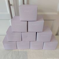 Stack of 10 KylieSkin Lavender Bath Bomb boxes in a pyramid shape, showing the brand and packaging.
