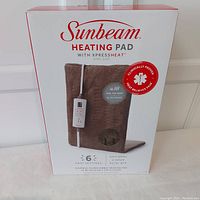 Front view of Sunbeam heating pad box with product image and features.