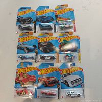 Overview photo showing all nine Hot Wheels cars in sealed packages arranged in a 3x3 grid on a white surface.