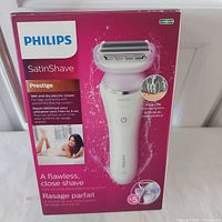Front of the Philips SatinShave Prestige box showing the shaver with foil and cutter head and branding, highlighting a flawless close shave.
