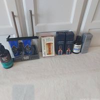 Photo showing all items from the lot arranged side by side, including beard washes, grooming kit in packaging, beard comb in box, beard thickener bottles, and serum box.