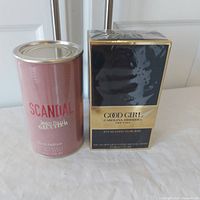 Photo of Jean Paul Gaultier Scandal and Carolina Herrera Good Girl Supreme perfume boxes, sealed in factory cellophane.
