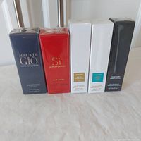 Front view of five sealed perfume boxes lined up