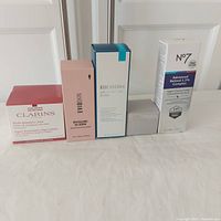 Front view of all five skincare product boxes lined up on cloth surface, showing size and branding