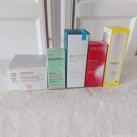 Front view of all five skincare product boxes in a row showing branding and size information.