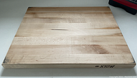 Top face of the Boos maple cutting board showing wood grain, branding on the side edge.
