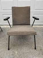 Front view of brown upholstered armchair on black steel frame