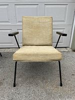 Front view of beige upholstered armchair on black steel frame