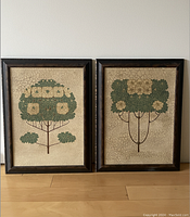 Both framed artworks together showing crackle finish on background, stylized green trees with flowers, and mottled dark brown frames.