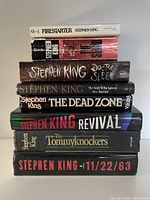 Stack of nine Stephen King books showing different titles with mix of hardcover and paperback covers in good condition.