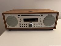 Front view of wood-cabinet music system showing speakers, control panel and CD slot