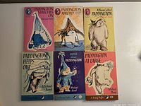 Photo of front covers of six Paddington Bear books showing colorful illustrated paperbacks by Michael Bond.