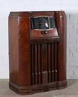 Full view of the Zenith vintage console radio showing wooden cabinet with curved edges and front speaker grille.