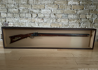 Full front view of shadow box showing entire deactivated flintlock rifle and frame