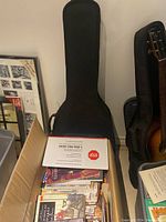 Cardboard box filled with books, one spiral notebook visible at center