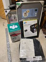 Lot items displayed together showing Umbra magnetic pushpin board frame, bed risers, trunk organizer, and IKEA chair cushions