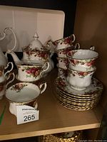 Shelf display of Old Country Roses teacups, saucers, teapot, sugar bowl and creamer