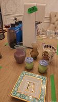 Photo of SodaStream appliance with bottles and assortment of glass and ceramic items on table