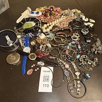 Top view showing entire lot of vintage jewelry including 9 watches, bracelets, necklaces, earrings, and brooches.