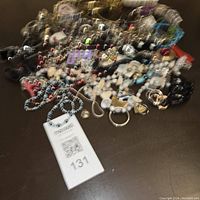 Blurred overview of mixed jewelry pieces including bracelets, pins, and necklaces in various colors and materials.