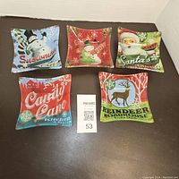 Top-down view of all five 5-inch Christmas-themed glass snack plates arranged with MaxSold lot number visible.