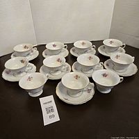 Full set of 11 teacups and 9 saucers arranged on table showing all items present.