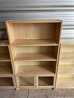 Front view of the IKEA wood finish bookcase showing three shelves and glass door cabinet below.