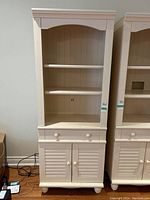 Front view of cream-coloured wall cabinet showing two shelves, drawer, and double-door cabinet below