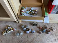 Various ceramic and brass drawer knobs laid out on surface showing colors and patterns clearly.