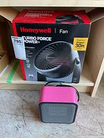 Honeywell Turbo Force fan box with pink Amazon space heater in front on floor.