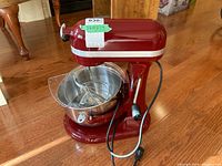 Front left view of mixer with bowl, wire whip, flat beater, dough hook installed inside and pour shield attached.