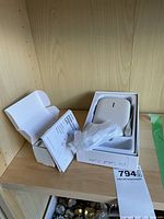 White label printer in original box with accessories, user manual, and extra tape.